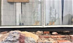 Detailaufnahme des Schaufensters, was von Künslter*innen bespielt wird. Hier sehen wir Biergläser mit Füßen aus Keramik.